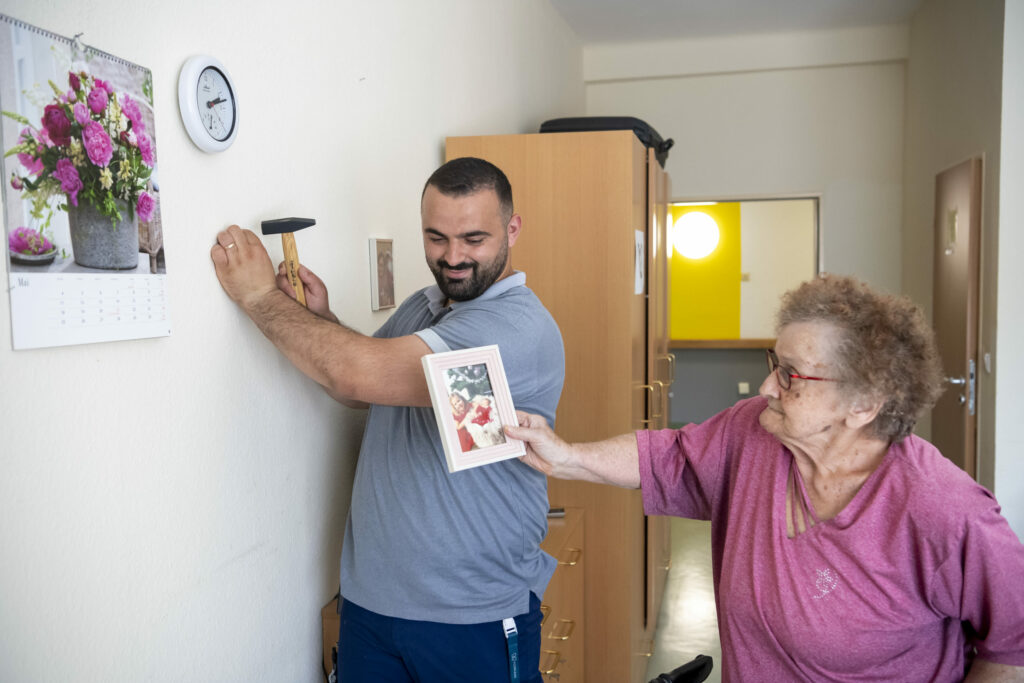 Korian_4003_Haus am grünen Weg Lollar_Pfleger_Bewohnerin_Bild aufhängen