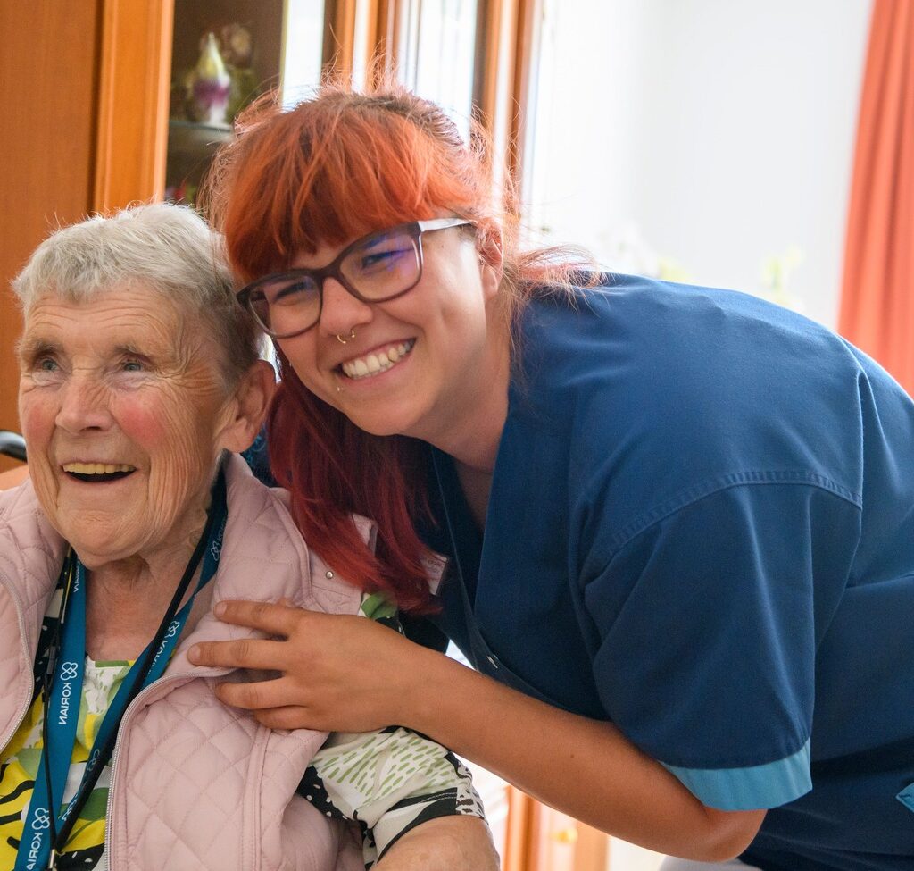 Weibliche Pflegekraft umarmt ältere Frau im Rollstuhl bei der häuslichen Betreuung durch den ambulanten Korian Pflegedienst Pflege und Betreuung zuhause am Jahnpark in Altenburg.