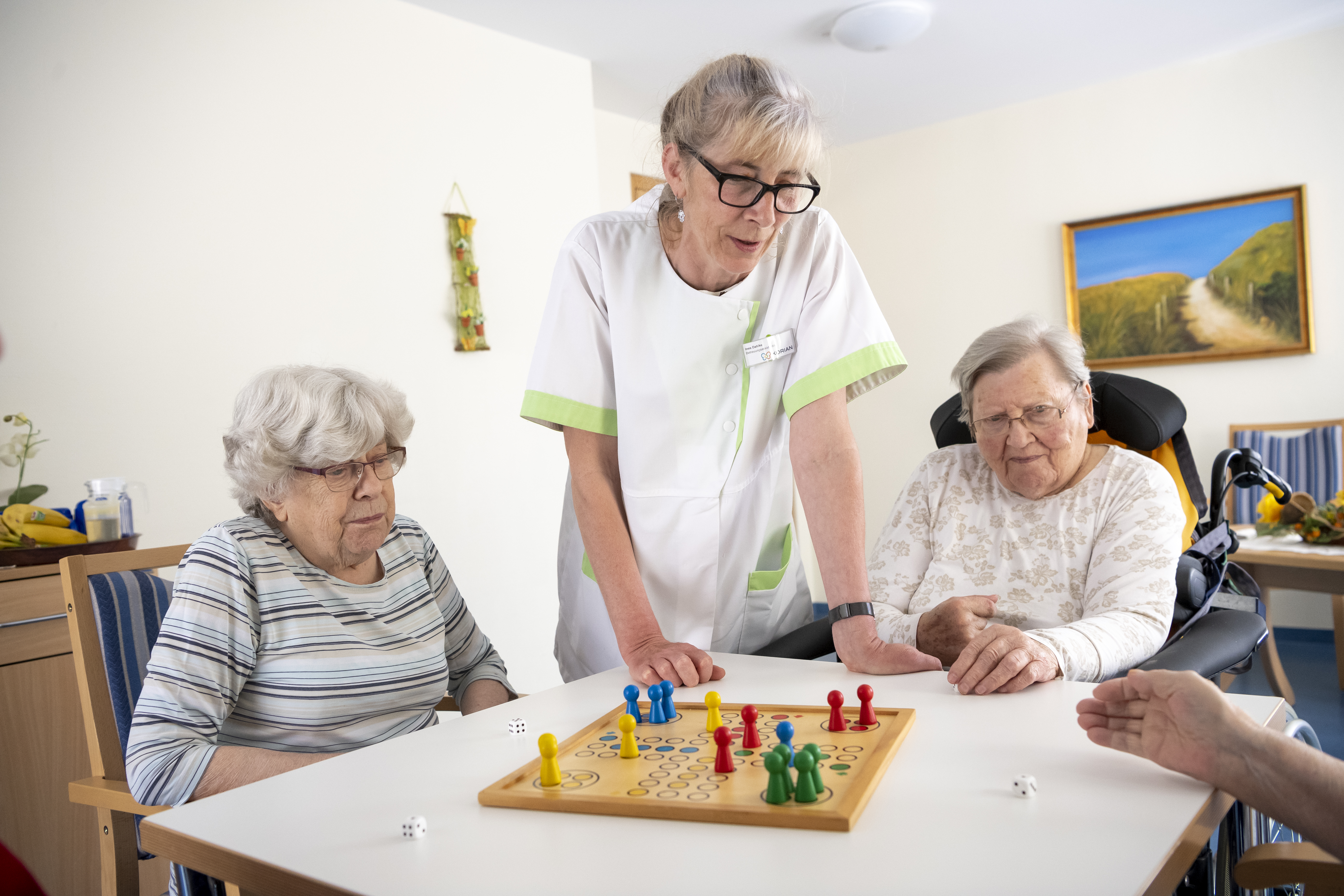 Korian_4070_Haus im Stadtfeld_Magdeburg_Brettspiel_Bewohnerinnen_Pflegerin