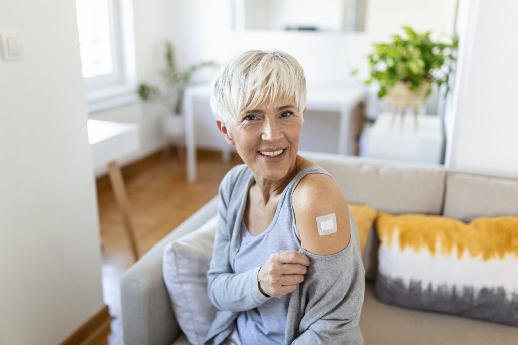 Adhesive bandage on arm after injection vaccine or medicine,ADHESIVE BANDAGES PLASTER - Medical Equipment,Soft focus Adhesive bandage on a female brachium after covid-19 vaccination